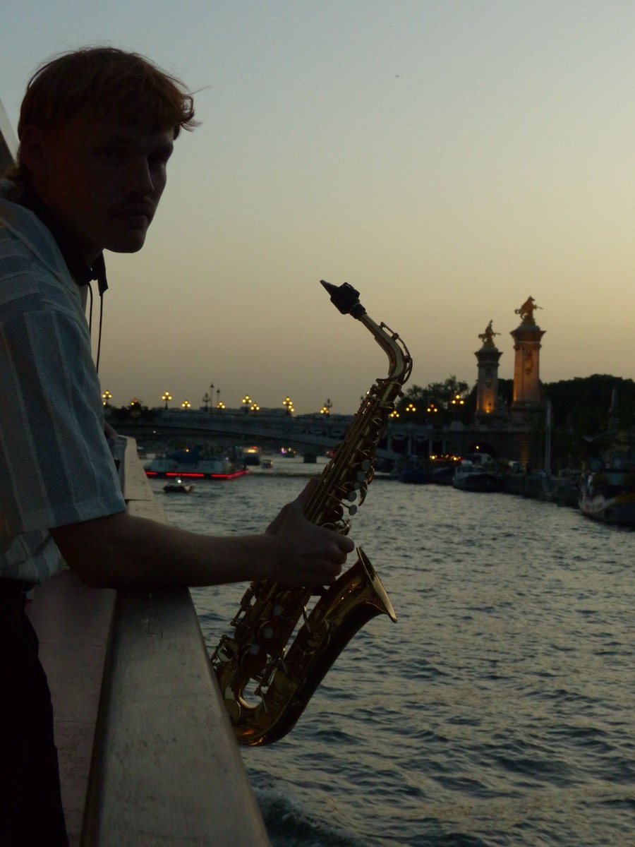 Hélion au saxophone sur un pont parisien au crépuscule